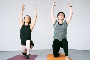 women kneeling on yoga mat